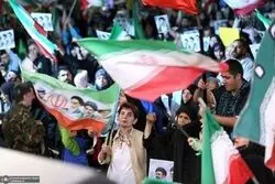 عکس | یک تصویر متفاوت؛ زن سلاح‌بدست روی موتور پشت سر نیروی نظامی در کنار پرچم جمهوری اسلامی ایران